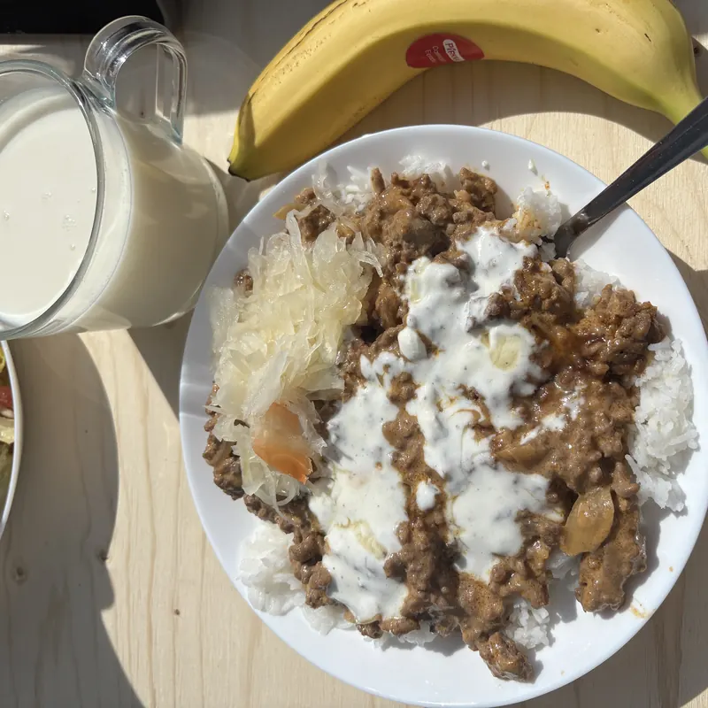 Riisiä ja jauhelihakastiketta jogurtilla, hapankaalia ja lasi maitoa